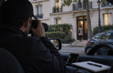 Procédure de divorce et surveillance par un détective privé Enquêteur photographiant depuis un véhicule une personne entrant dans un immeuble parisien